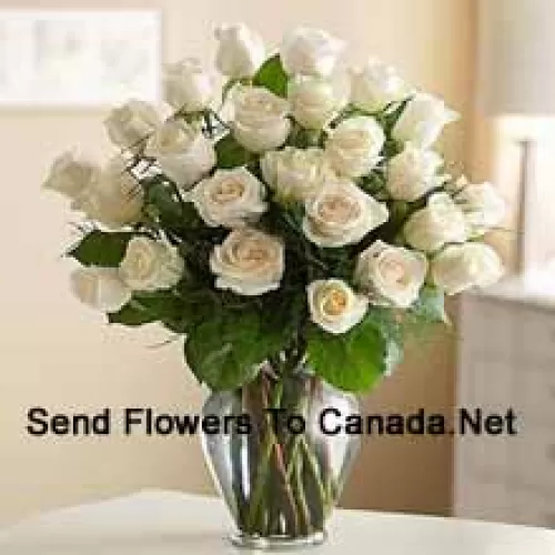 25 White Roses With Some Ferns In A Glass Vase