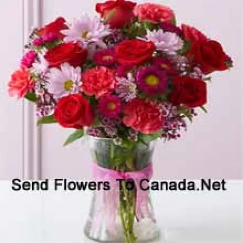 Red Roses, Red Carnations And Other Assorted Flowers Arranged Beautifully In A Glass Vase