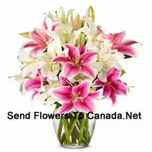 White And Pink Lilies With Some Ferns In A Glass Vase